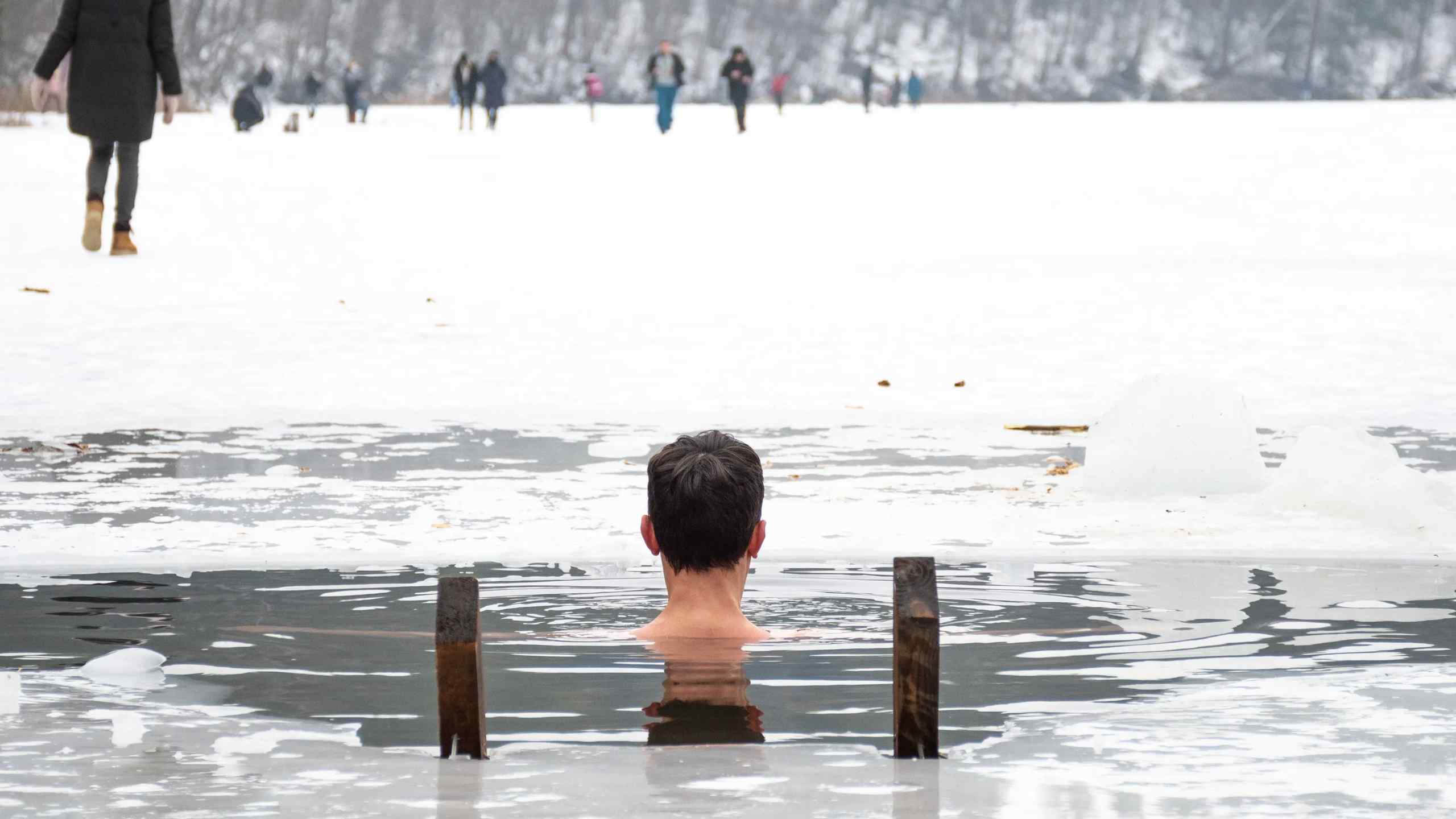 A lone man treading water in nearly frozen water
